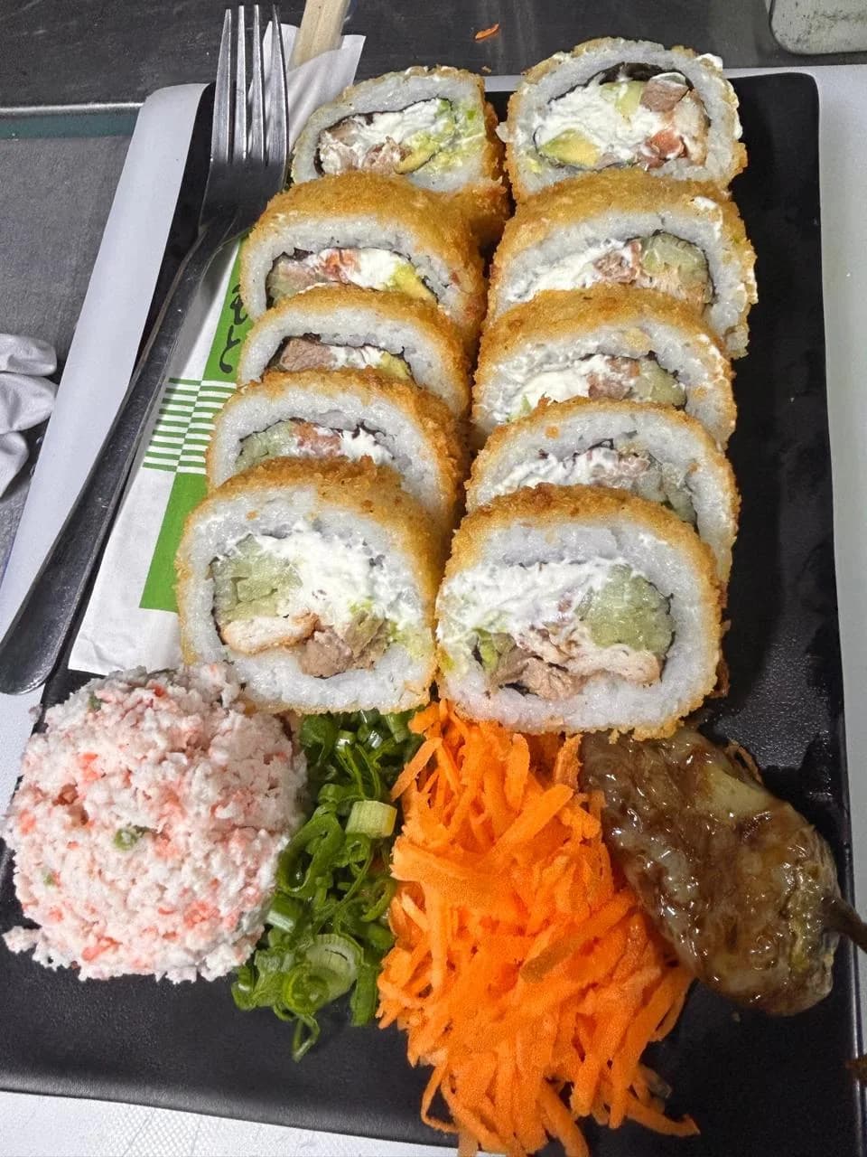 Rollo empanizado servido en plato rectangular negro